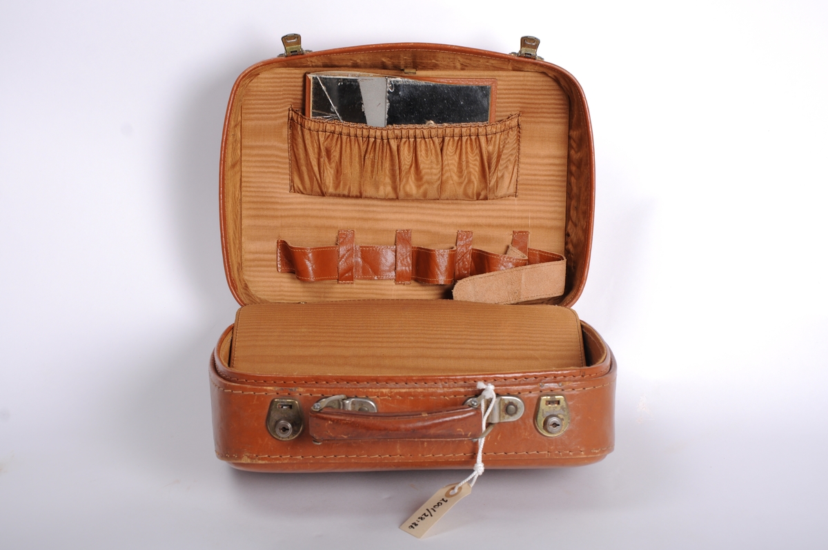 Beautybox i okselær. Produsert av DNR ca 1960. Lærvare og nr 13 er DNR#s nre. Brukt til skolegang av Bente Skjoldmo (Skaar) Kjøpt i Bergen Reis. Opplysninger ihht lapp i vesken.