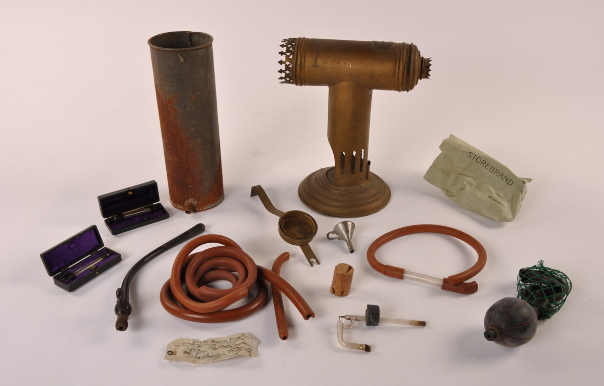 Inhalator i metall med utstyr. Gummislanger, blåse, metallsylinder, glassrør, trakt, kork, to sett med sprøyter i esker.