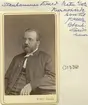 Porträtt av Evald Stenhammar. Född i Häradshammar 1824 som son till prosten Christian Stenhammar och makan Anna Charlotta Kernell. Efter teologiska studier vid Uppsala universitet inflyttade han till Linköping 1865 för tjänst som adjunkt vid stadens läroverk. Efter en tid åter i Uppsala för fortsatta studier och vidare som prästvigd docent inflyttade han 1876 en andra gång till Linköping, nu tillsammans med hustrun Anna Charlotta Holmberg och parets fyra barn. Skälet var erbjudande om tjänst som så kallad domkyrkosyssloman vid sidan av kyrkoherde i Vreta kloster och Stjärnorp. Från år 1878 var familjen bosatt i Vreta klosters kyrkoherdeboställe.