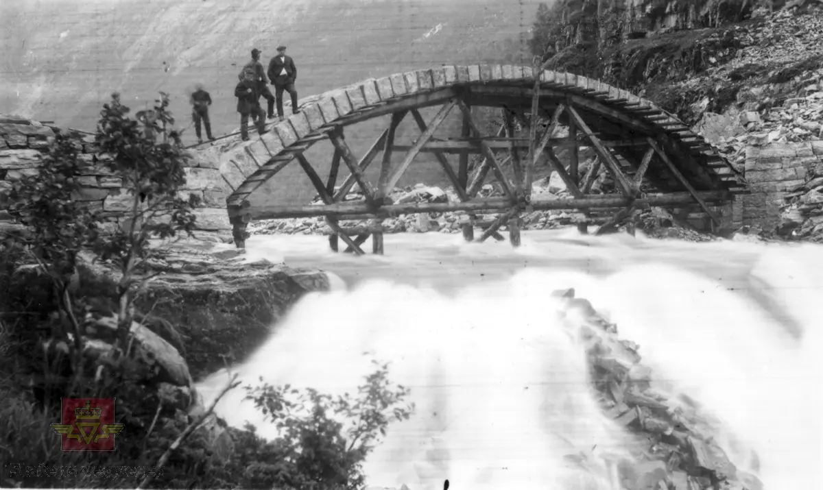 Gallefoss steinkvlevingsbru år 1911 sett mot aust, omlag midt i Guddal i Fjaler kommune. Visar fyrste etappe av brubygget og legg merke til at ingen stolpar under brua står lodrett.

(Informant: Per Birger Lomheim, pensjonert tilsett i Statens vegvesen i Sogn og Fjordane.)

Sjå og motiva NVM 00-F-40022 og NVM 00-F-40023.