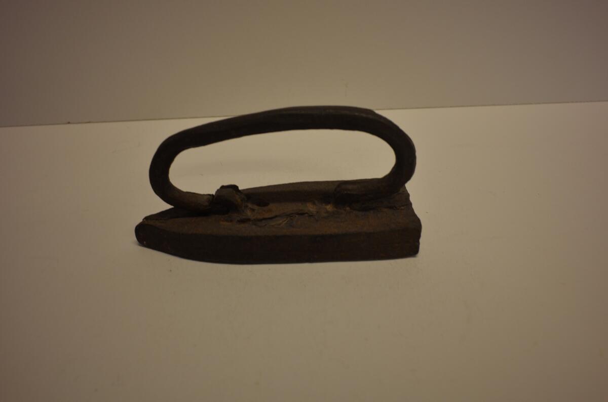 Strykjärn av järn. Bygelformigt handtag. Enligt uppgift från senare hälften av 1700-talet. Ö. Tåsjö, Tåsjö, Ångermanland