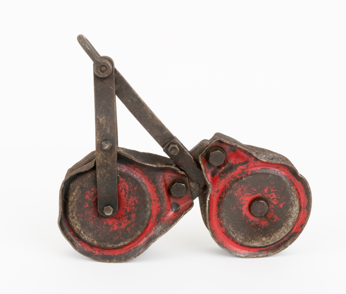 Løpekatt for slepebane som består av to kraftige blokker med oppheng i et mellomstykke konstruert av flattjern. Hver blokk består av en roterende skive, to sideplater (en på hver side av skiven) og en gjennomgående festebolt i midten. Blokkens skive har et spor der ståltauet, som lasten henges i, legges. Øverst på blokkene er det gjennombrutt hull i sideplatene. Blokkene er festet til mellomstykket med bolter som er tredd gjennnom hullene i sideplatene. På toppen av opphenget er det festet en sjakkel. Løpekatten er preget av bruk og er preget av en del ytre påkjenninger. En slik løpekatt kunne f. eks. brukes med traktormontert stammelunningsvisnj som var tilleggsutstyrt for stammelunning med slepebane.   
(Løpekattens bruk sammen traktormontert vinsj, se vedlagt fil under fanen "Referanser til filer")

Løpekatten er brukt som hjelpeutstyr i forbindelse med transport av tømmer med vinsj i bratt og ulendt terreng. I løpekatten festes lasset for transport. Løpekatten henger på kabelkranas bærekabel. Løpekatten fører tømmeret langs bærekabelen enten oppover eller nedover dalsiden.