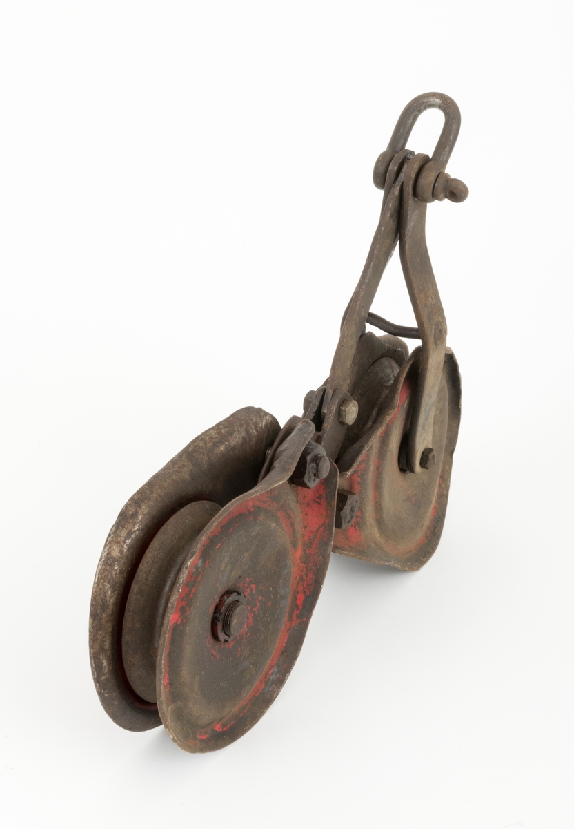 Løpekatt for slepebane som består av to kraftige blokker med oppheng i et mellomstykke konstruert av flattjern. Hver blokk består av en roterende skive, to sideplater (en på hver side av skiven) og en gjennomgående festebolt i midten. Blokkens skive har et spor der ståltauet, som lasten henges i, legges. Øverst på blokkene er det gjennombrutt hull i sideplatene. Blokkene er festet til mellomstykket med bolter som er tredd gjennnom hullene i sideplatene. På toppen av opphenget er det festet en sjakkel. Løpekatten er preget av bruk og er preget av en del ytre påkjenninger. En slik løpekatt kunne f. eks. brukes med traktormontert stammelunningsvisnj som var tilleggsutstyrt for stammelunning med slepebane.   
(Løpekattens bruk sammen traktormontert vinsj, se vedlagt fil under fanen "Referanser til filer")

Løpekatten er brukt som hjelpeutstyr i forbindelse med transport av tømmer med vinsj i bratt og ulendt terreng. I løpekatten festes lasset for transport. Løpekatten henger på kabelkranas bærekabel. Løpekatten fører tømmeret langs bærekabelen enten oppover eller nedover dalsiden.