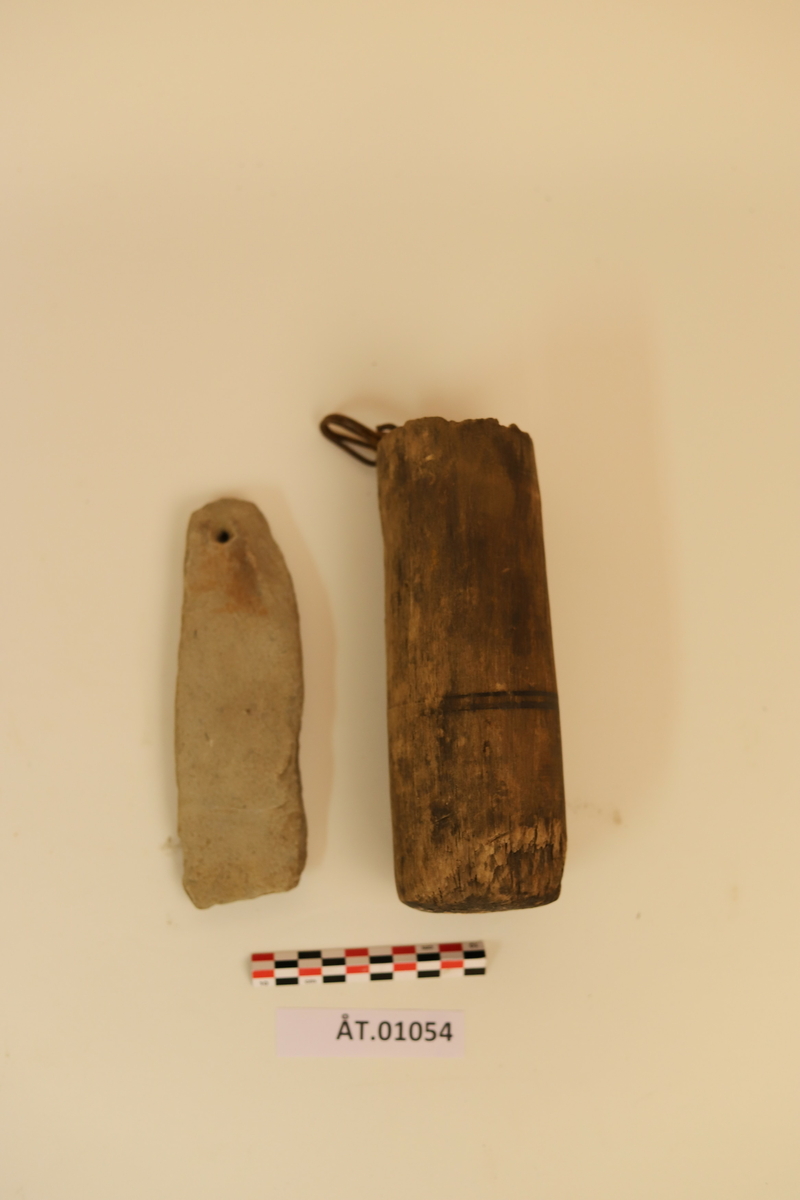 Trekopp til å ha bryne i. Koppen er hulet ut av et stykke tre med en metallkrok i toppen. Rundt koppen er det to sorte striper som er malt på. Under metallkroken er det en reparasjon med noe hvitt. Inni er en brynesten som er tynnere i tuppen og hull i enden. Stenen er lysegrå. Koppen bærer preg av sprekker og oppleves som litt skjør. 