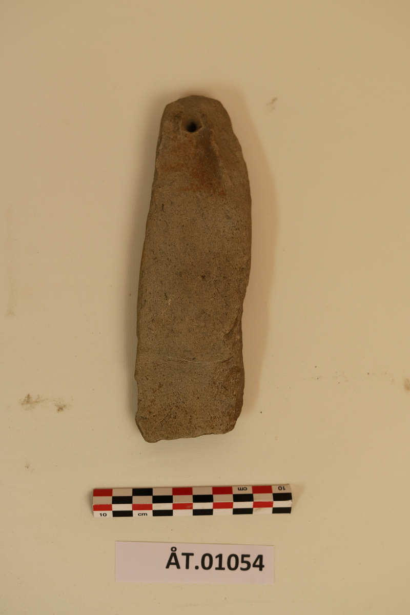 Trekopp til å ha bryne i. Koppen er hulet ut av et stykke tre med en metallkrok i toppen. Rundt koppen er det to sorte striper som er malt på. Under metallkroken er det en reparasjon med noe hvitt. Inni er en brynesten som er tynnere i tuppen og hull i enden. Stenen er lysegrå. Koppen bærer preg av sprekker og oppleves som litt skjør. 