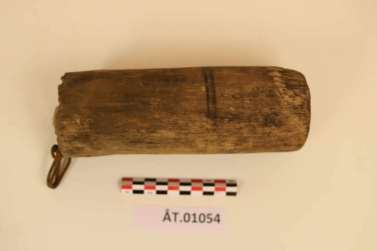 Trekopp til å ha bryne i. Koppen er hulet ut av et stykke tre med en metallkrok i toppen. Rundt koppen er det to sorte striper som er malt på. Under metallkroken er det en reparasjon med noe hvitt. Inni er en brynesten som er tynnere i tuppen og hull i enden. Stenen er lysegrå. Koppen bærer preg av sprekker og oppleves som litt skjør. 