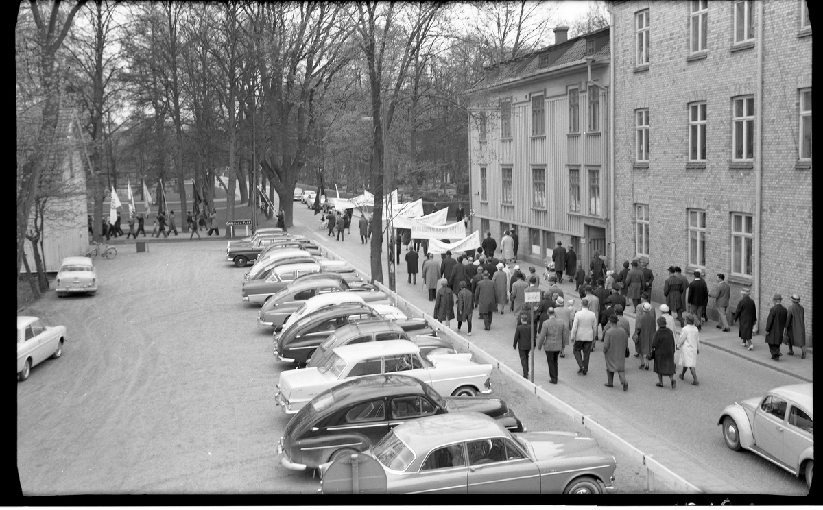 Demonstrationståg på 1:a maj, 1:a majdemonstration. 

Man svänger av från Västra Kyrkogatan vid Plantaget mot Nolhaga park. Man demonstrerar bland annat för ett nyktrare Sverige. 

I kv Älgen invigdes en ny EFS-kyrka 1975.