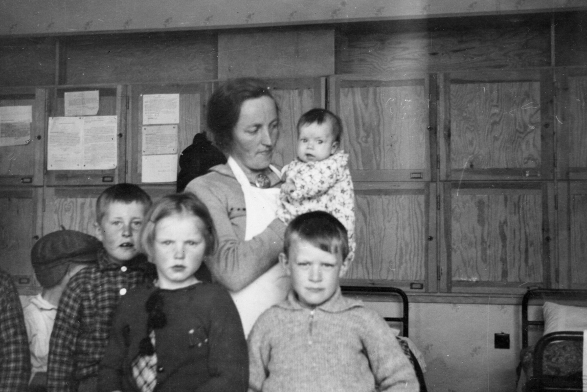 Storetveit skole i Bergen. Sju personer. Fem ansikt. En arm. Et halvt skjult hode. Fra venstre: Olav Øvretveit, Marta Nelly Selstø, Mikal B. Selstø. Bak: Gerda Øvretveit, Målfrid Øvretveit.