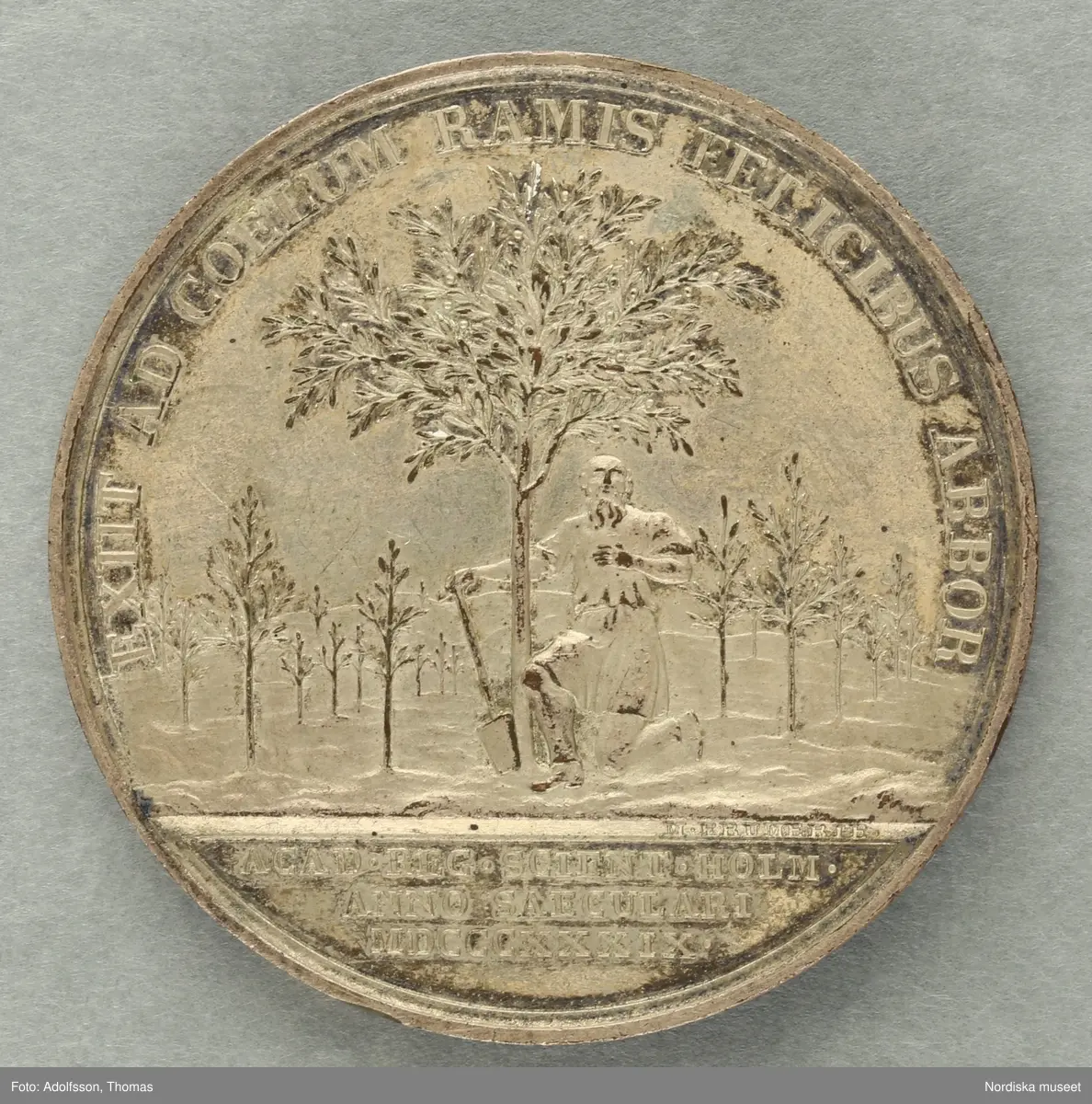 Huvudliggaren:
a-c
"3 minnespenningar. Öfver Karl XIV Johan.
a) I silfver. Jmfr Hildebrand, del II, sid 344, nr 34
b) I silfver. Jmfr H-d. del II, sid 345, nr 35.
c) I brons. Lika med b.
