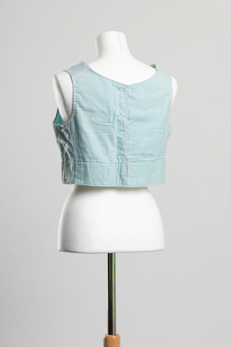 Hjemmelaget formsydd underliv av turkis bomullsflanell uten ermer. Åpning i front med knappelukkning, fem perlemorsknapper.