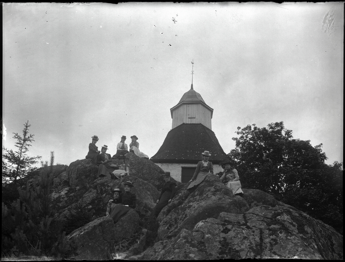 Kvinnor samlade på klippa framför kyrktorn