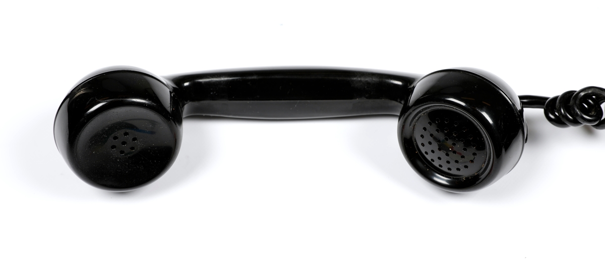 Svart telefonapparat i plast med sveiv, men uten tallskive.
Telefoner uten tallskive var tilknyttet manuelle telefonsentraler, og en brukte sveiva for å kommer i kontakt med sentralen, hvor det falt en klaff over linjejakken, et hvitt flagg og på større sentraler et lys over linjejakken. 
Denne het Elektrisk Burerau 1953 modell og ble produsert til 1967 i et antall 153 400 eksemplarer