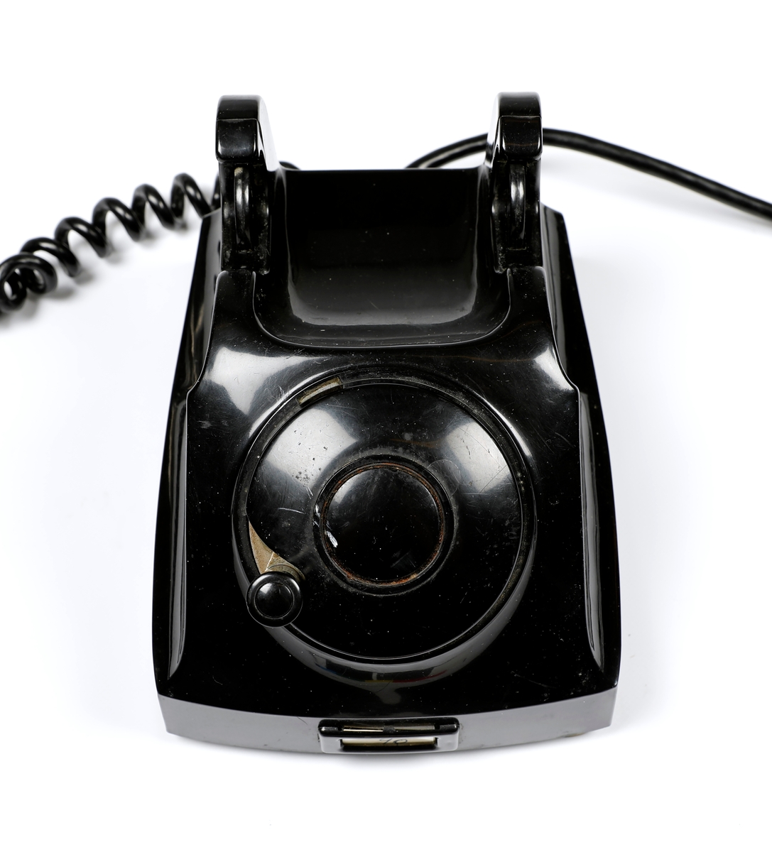 Svart telefonapparat i plast med sveiv, men uten tallskive.
Telefoner uten tallskive var tilknyttet manuelle telefonsentraler, og en brukte sveiva for å kommer i kontakt med sentralen, hvor det falt en klaff over linjejakken, et hvitt flagg og på større sentraler et lys over linjejakken. 
Denne het Elektrisk Burerau 1953 modell og ble produsert til 1967 i et antall 153 400 eksemplarer