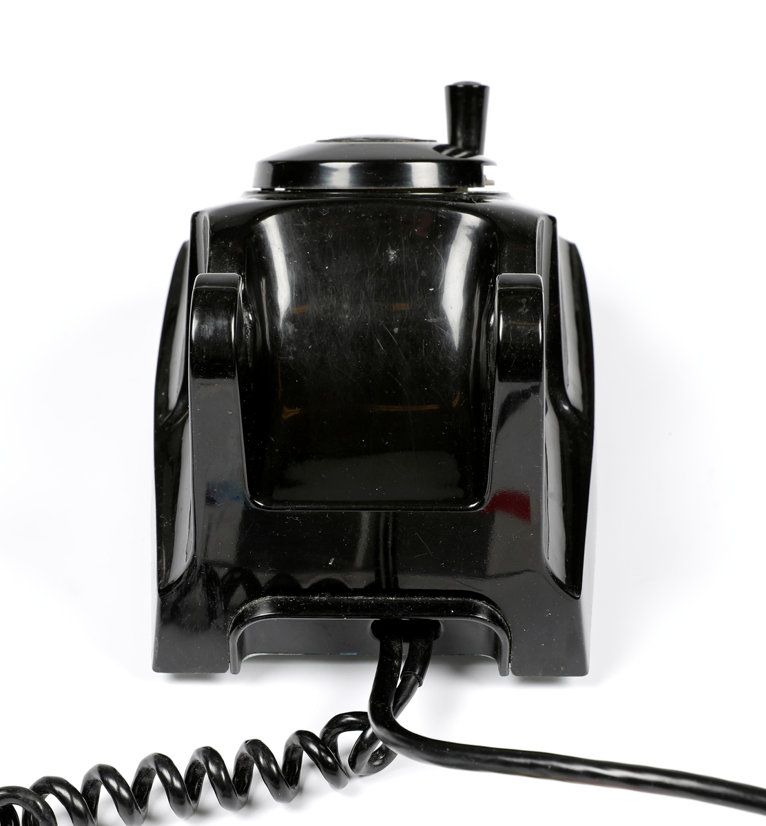 Svart telefonapparat i plast med sveiv, men uten tallskive.
Telefoner uten tallskive var tilknyttet manuelle telefonsentraler, og en brukte sveiva for å kommer i kontakt med sentralen, hvor det falt en klaff over linjejakken, et hvitt flagg og på større sentraler et lys over linjejakken. 
Denne het Elektrisk Burerau 1953 modell og ble produsert til 1967 i et antall 153 400 eksemplarer