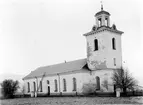 Nora Kyrka. Byggmästare Simon Geting. Vitputsad stenkyrka med rektangulärt långhus och torn i väster. Nyklassicistisk stil.