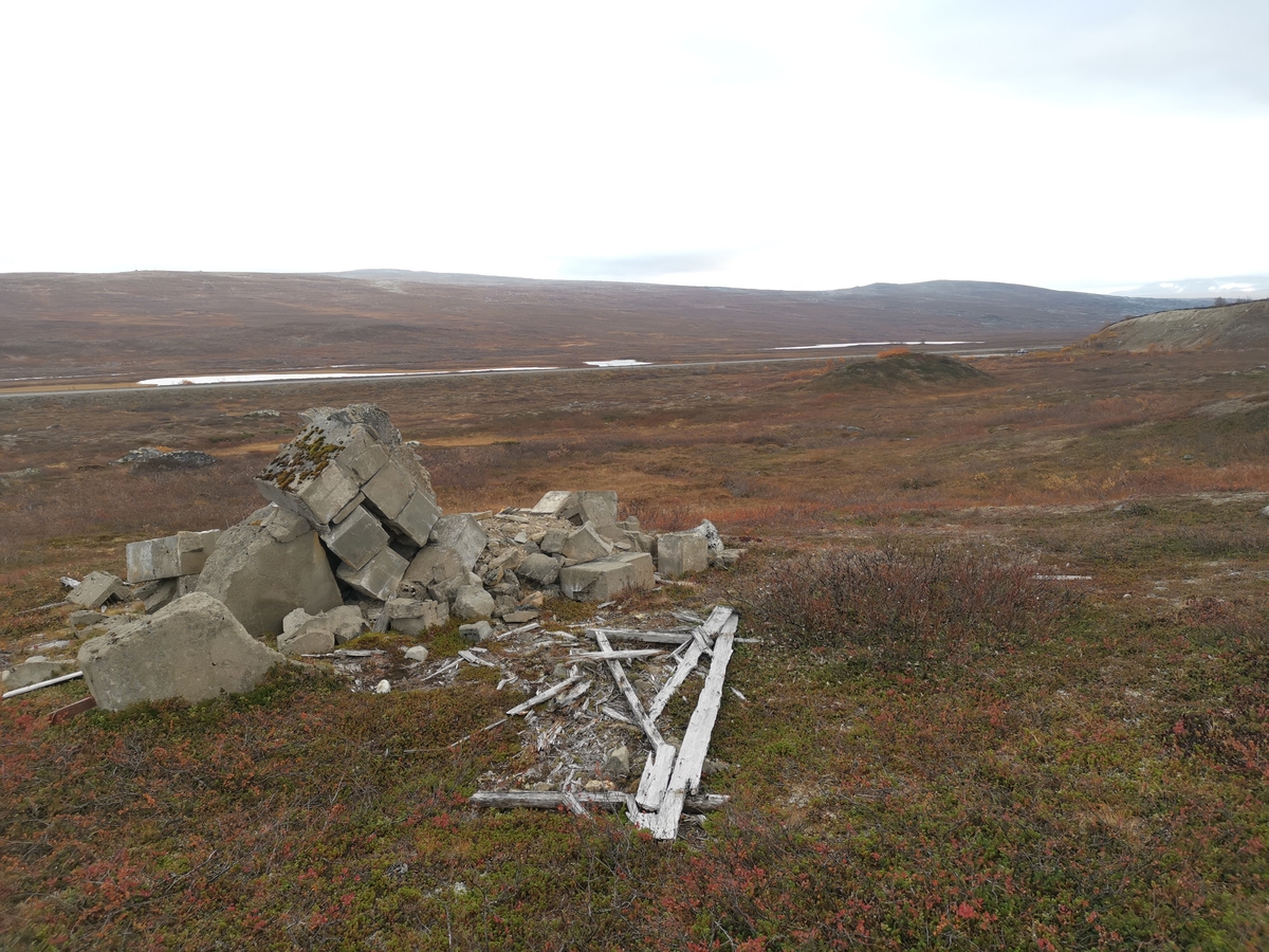 Rester av minnesmerke på den tidligere krigsgravplassen ved Bjørnelva fangeleir like ved Sukkertoppen på Saltfjellet. Her ble 207 sovjetiske krigsfanger gravlagt. Etter krigens slutt reiste gjenlevende fanger to minnesmerker på gravplassen. Bildet viser restene av det ene minnesmerket. Det hadde følgende tekst på russisk: "Her er stedt til hvile 300 russiske soldater og offiserer i Den Røde Armé som ble dyrisk pint av den fascistiske terror i 1944–45." Gravene ble flyttet til Hestbrinken like etter 2. verdenskrig, og i 1951 til Tjøtta (Operasjon Asfalt). Minnesmerket ble sprengt av norske myndigheter i 1950.