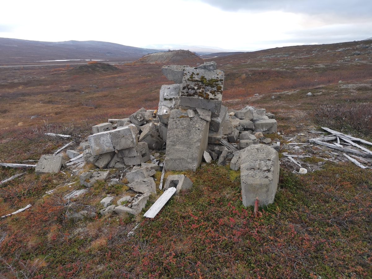 Rester av minnesmerke på den tidligere krigsgravplassen ved Bjørnelva fangeleir like ved Sukkertoppen på Saltfjellet. Her ble 207 sovjetiske krigsfanger gravlagt. Etter krigens slutt reiste gjenlevende fanger to minnesmerker på gravplassen. Bildet viser restene av det ene minnesmerket. Det hadde følgende tekst på russisk: "Her er stedt til hvile 300 russiske soldater og offiserer i Den Røde Armé som ble dyrisk pint av den fascistiske terror i 1944–45." Gravene ble flyttet til Hestbrinken like etter 2. verdenskrig, og i 1951 til Tjøtta (Operasjon Asfalt). Minnesmerket ble sprengt av norske myndigheter i 1950.