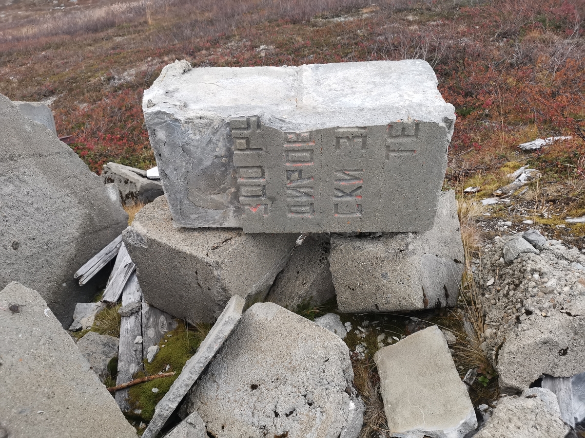 Rester av minnesmerke på den tidligere krigsgravplassen ved Bjørnelva fangeleir like ved Sukkertoppen på Saltfjellet. Her ble 207 sovjetiske krigsfanger gravlagt. Etter krigens slutt reiste gjenlevende fanger to minnesmerker på gravplassen. Bildet viser restene av det ene minnesmerket. Det hadde følgende tekst på russisk: "Her er stedt til hvile 300 russiske soldater og offiserer i Den Røde Armé som ble dyrisk pint av den fascistiske terror i 1944–45." Gravene ble flyttet til Hestbrinken like etter 2. verdenskrig, og i 1951 til Tjøtta (Operasjon Asfalt). Minnesmerket ble sprengt av norske myndigheter i 1950.