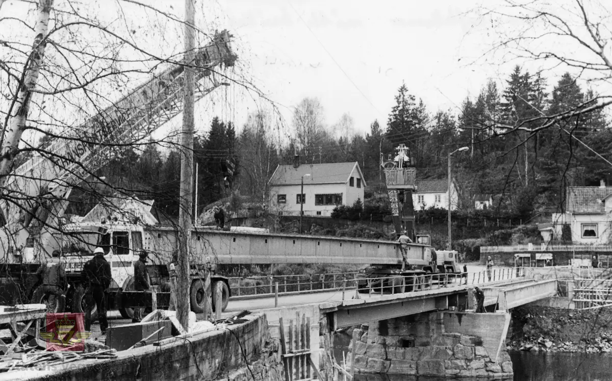 Tungtransport, transport av betongbjelke til ny gangbru ved Sunde bru, Gjerstad 1984. Store løftekraner måtte brukes når de to bjelkene skulle monteres på plass oppstrøms gammel bru.
Bjelker på 29,2 og 21,6 meter monteres som gangveg. Den minste NIB-bjelken er alt på plass. Den store klargjøres til montering. Operasjonen gikk problemfritt, og det ble ikke nødvendig med mer enn halvtimes stopp av gangen for trafikken. 

Ref. til Sørlandsporten Nr.1-1985. Side 6.
Bedriftsavis for Statens vegvesen Aust-Agder.

Stedsnavn: Sunde bru