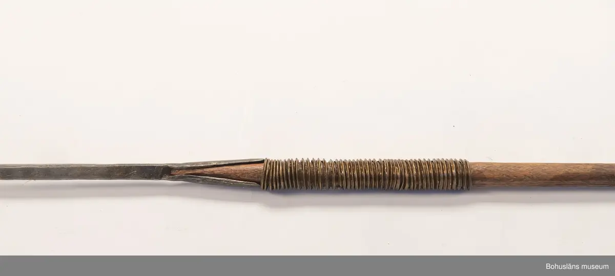 Ur handskrivna katalogen 1957-1958:
Jaktspjut; Afrika
L. 202,5 cm; i ena ändan järnblad, i andra pik av järn; träskaft; delvis lindat m. mässing. Helt.

Lappkatalog: 9