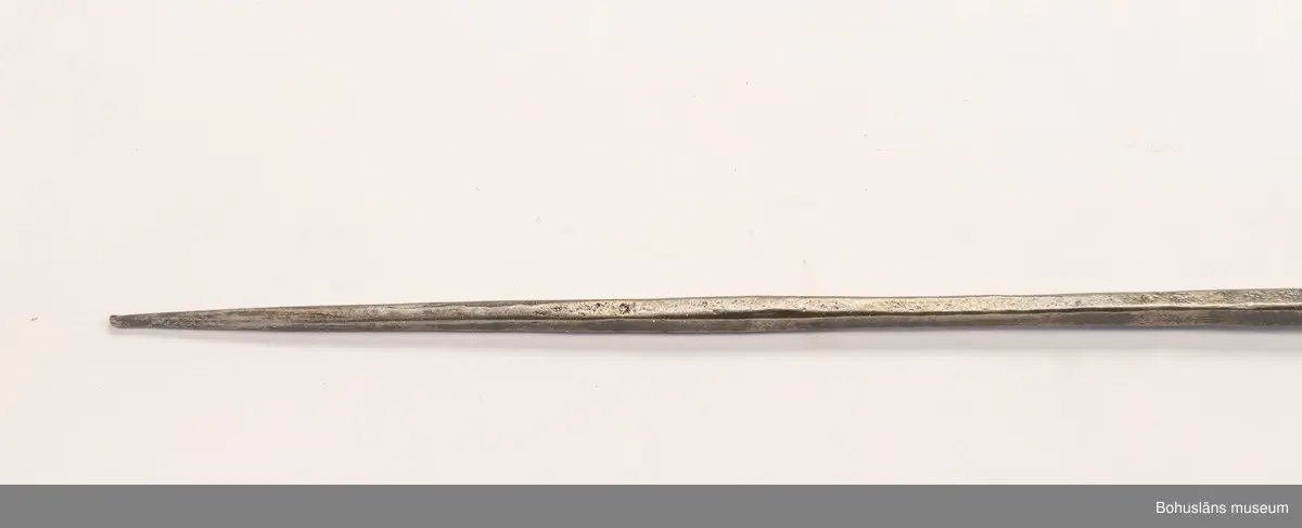 Ur handskrivna katalogen 1957-1958:
Jaktspjut; Afrika
L. 202,5 cm; i ena ändan järnblad, i andra pik av järn; träskaft; delvis lindat m. mässing. Helt.

Lappkatalog: 9