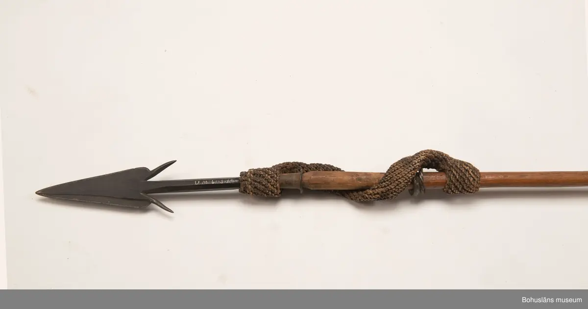 Kontinent: Afrika.

Ur lappkatalogen:
Harpun, l. 179 cm. Järnspets, l. 26,5 cm, försedd med två hullingar o. fästad vid skaftet med grovt, flätat rep. Träskaft ornerat med inskuren imitation av surrade mässingsband. Bakändan virad med järntråd.

Uppgifter om E. Göransson i Knut Adrian Anderssons katalog samt historik om samlingen: Se UM61.3.1.