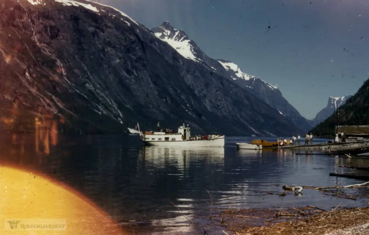 Eikesdalen. Kaia i Sandgrovosen, Eikesdalen..«Gamle Eikesdal» som gjekk i rute 1896-1960, er her klar til å legge til kai ein søndag(?). Kaia vart bygd 1939. Den brun-gule motorbåten er frå Vike. Naustet tilhøyrer gnr. 79/7. Det brann 1982.