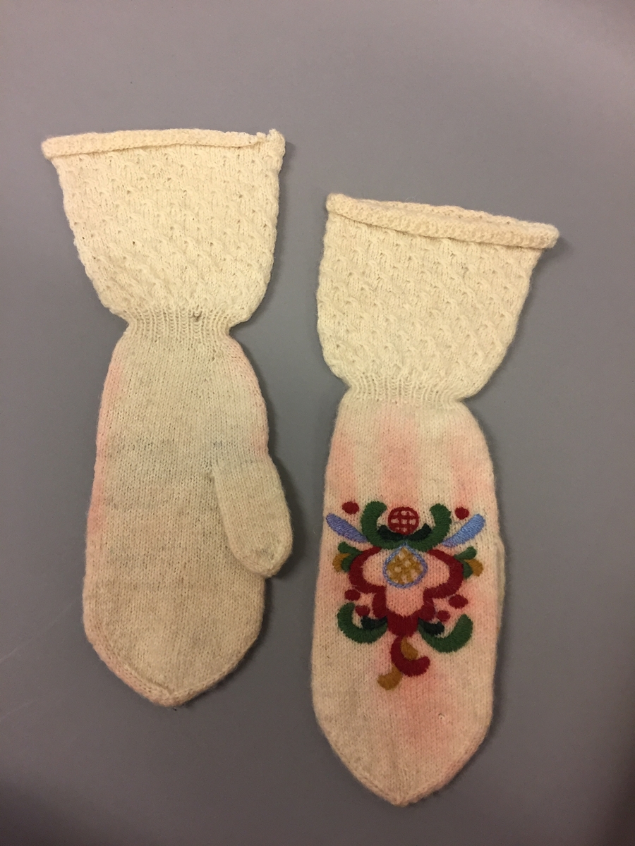 Heimestrikka vottar i glattstrikk med rosesaum. Vottane har mønsterstrikk på velet. Ikkje tommelkile. Strikka av heimespunne garn. Plattsaum i sterke fargar,saumen har farga noko av.