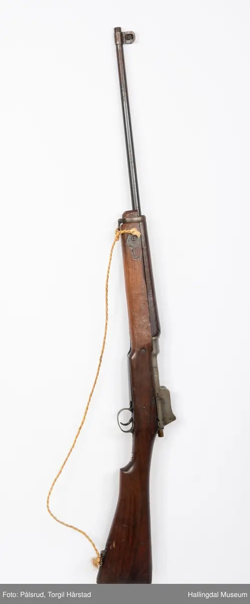 Engelsk Lee-Enfield rifle. Brukt under andre verdenskrig i Norge. 
Framstokken er noe avkappet - mulig i forbindelse med ombygging til jaktvåpen. 
Kaliber: .303 British. 
Geværet har et surret hampetau til reim - ikke original.