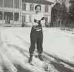 Porträttfoto av Anna Linderstam i skidklädsel utanför byggnad, vintertid, cirka 1925. Helbild.

Text vid foto: 