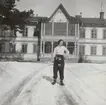 Porträttfoto av Anna Linderstam i skidklädsel utanför byggnad, vintertid, cirka 1925.

Text vid foto: 