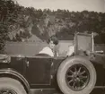 Anna Linderstam sitter i en bil på en väg nedanför Brahehus, 1925.

Text vid foto: 