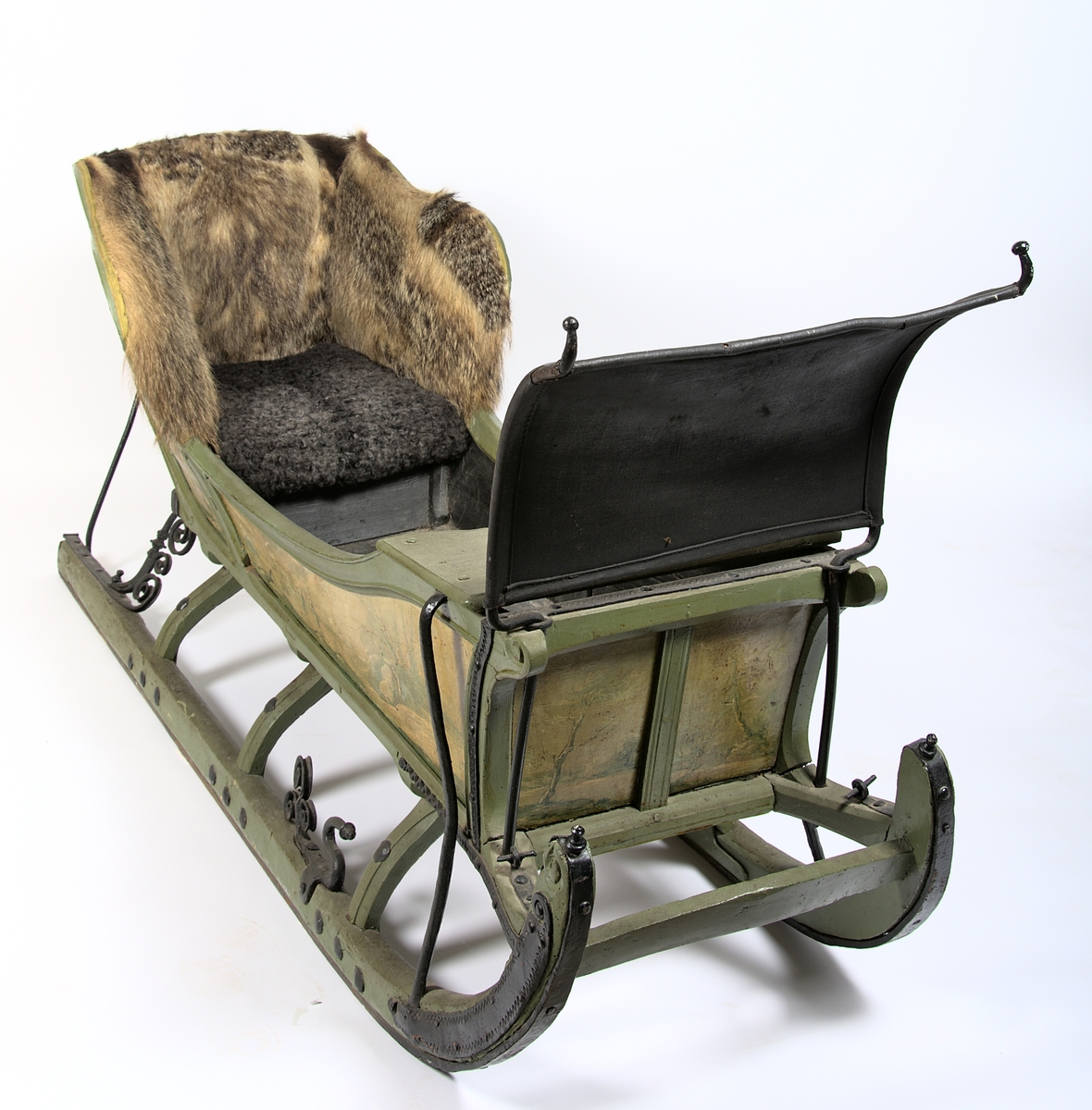 Släde, enspännare av furuträ. Grönmålad. Med järnbeslag. Kuskbockssadel ("hundsfott") samt plats för en passagerare. I sätet en infälld lucka, förvaringsutrymme. Kuskbocksbrädan samt sätets sid- och ryggstycken stoppade med hö, foder juteväv, klädda med grävlingskinn. Framtill stänkskydd för passageraren av svart impregnerad duk

Rikt dekorerad med målningar i Rokokostil.