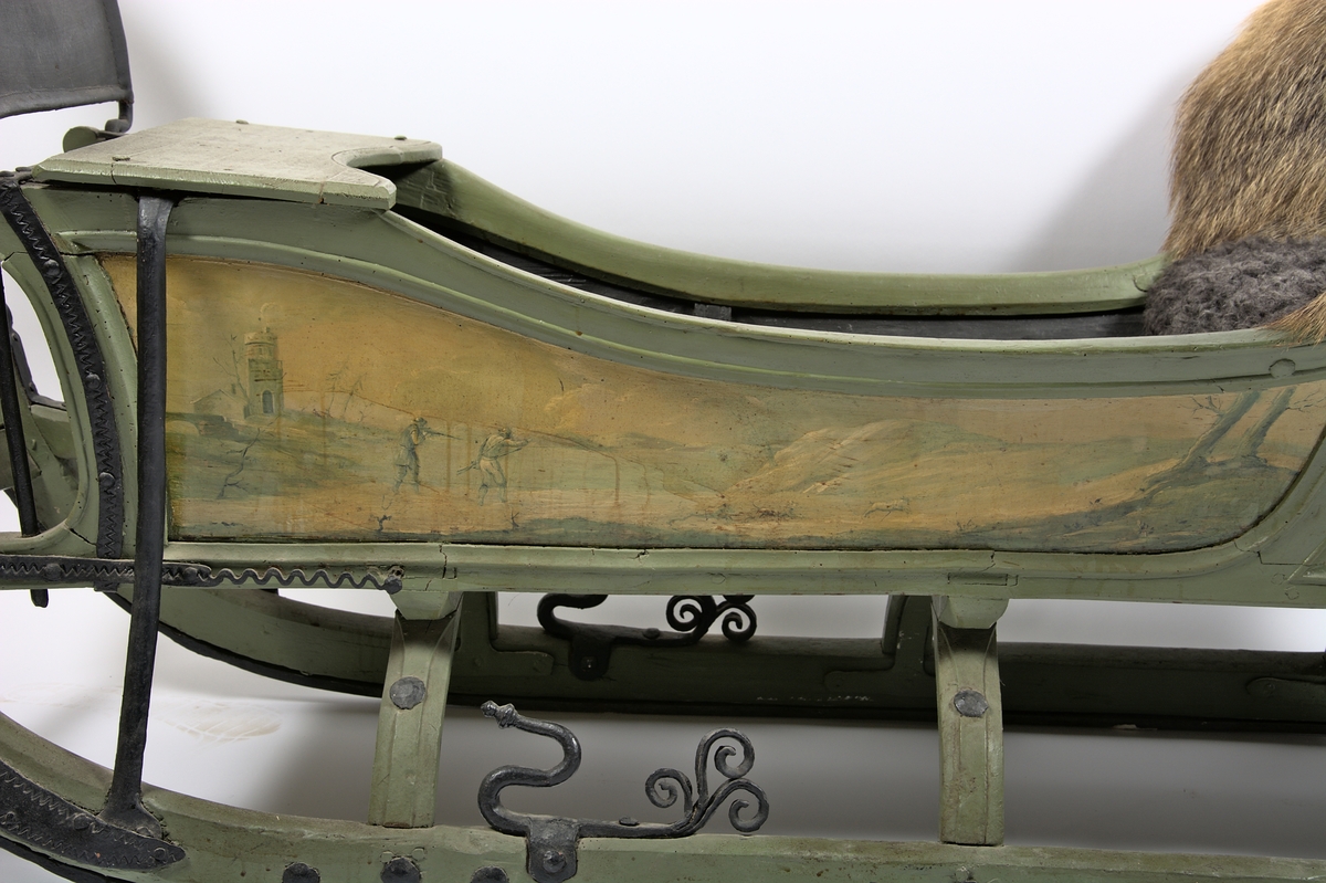 Släde, enspännare av furuträ. Grönmålad. Med järnbeslag. Kuskbockssadel ("hundsfott") samt plats för en passagerare. I sätet en infälld lucka, förvaringsutrymme. Kuskbocksbrädan samt sätets sid- och ryggstycken stoppade med hö, foder juteväv, klädda med grävlingskinn. Framtill stänkskydd för passageraren av svart impregnerad duk

Rikt dekorerad med målningar i Rokokostil.