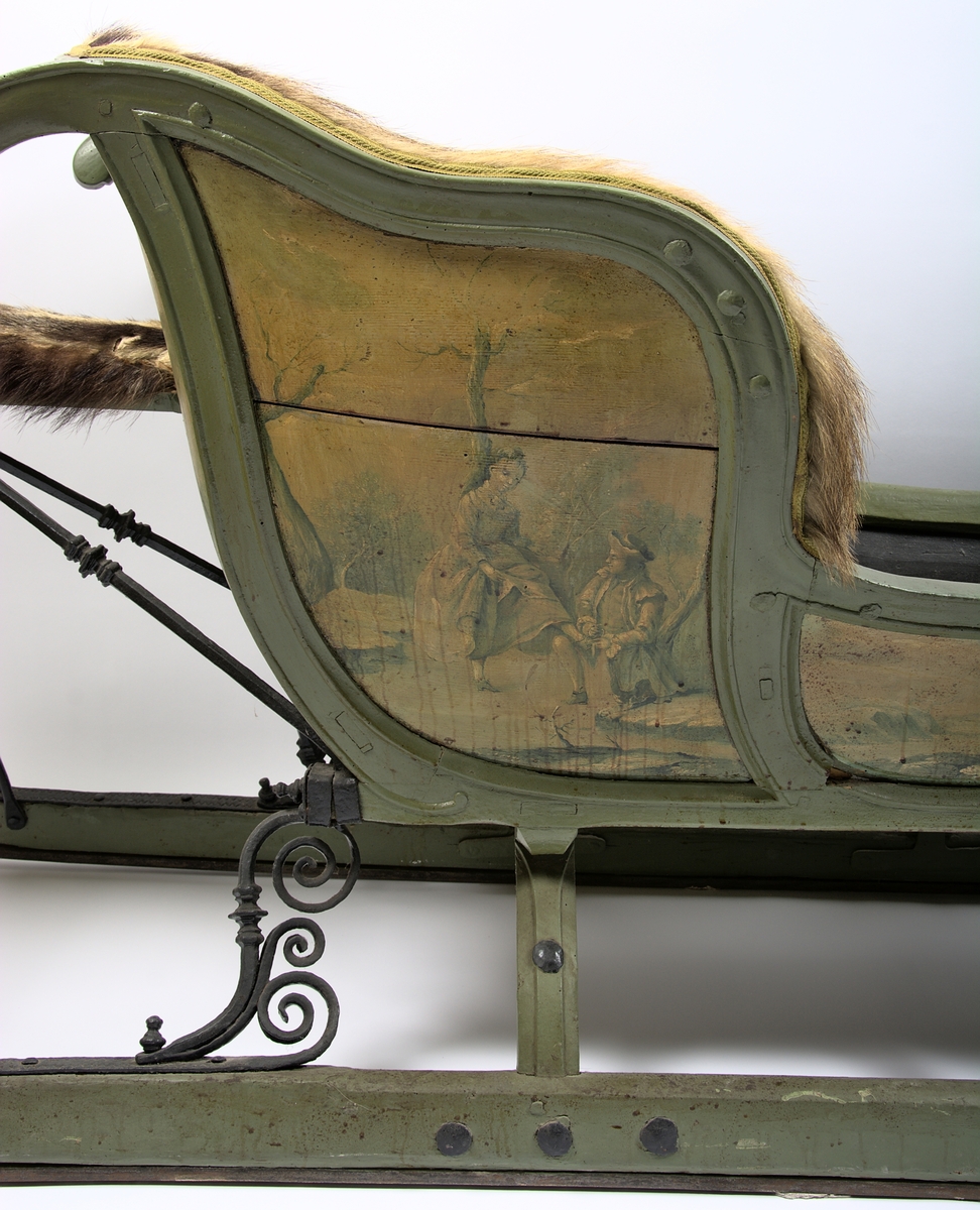 Släde, enspännare av furuträ. Grönmålad. Med järnbeslag. Kuskbockssadel ("hundsfott") samt plats för en passagerare. I sätet en infälld lucka, förvaringsutrymme. Kuskbocksbrädan samt sätets sid- och ryggstycken stoppade med hö, foder juteväv, klädda med grävlingskinn. Framtill stänkskydd för passageraren av svart impregnerad duk

Rikt dekorerad med målningar i Rokokostil.