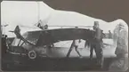 Flygplan M 2, Nieuport IV-G inför första provflygningen, på Malmen den 23 september 1913. I förarsitsen varmkör Gösta von Porat motorn. Längst till höger står Lars Fjällbäck (i hatt), till vänster om honom Allan Jungner.