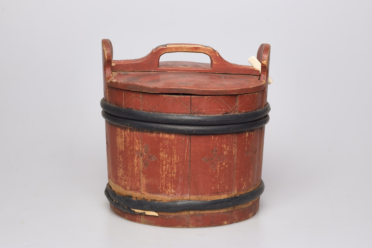 Lagging med tre gjorder, men én mangler. Lokk og ører, uten bein. Formen er rund, lokket er utenpåliggende og har håndtak. Påmalt rød farge, og dekorert med roser og streker. Brukt til oppbevaring av ost.