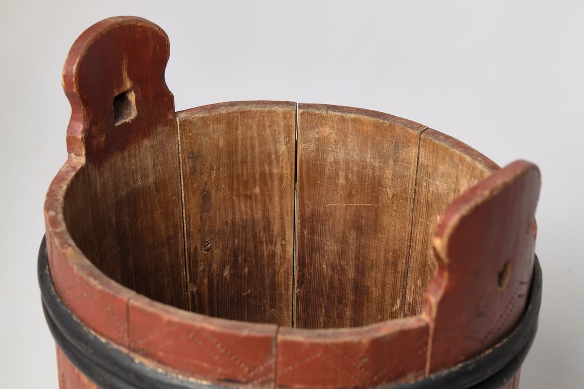 Lagging med tre gjorder, men én mangler. Lokk og ører, uten bein. Formen er rund, lokket er utenpåliggende og har håndtak. Påmalt rød farge, og dekorert med roser og streker. Brukt til oppbevaring av ost.