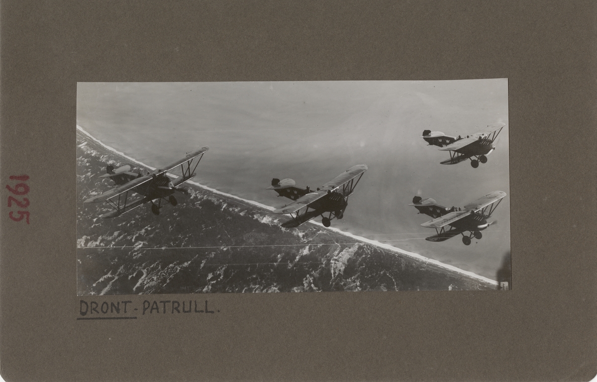 Fyra flygplan Phönix Dront flyger längs kust, 1925. Flygbild uppifrån.

Text vid foto: "Dront-patrull. 1925."