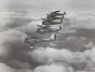 Fem flygplan J 7 Bristol Bulldog flyger i formation ovan moln. Vid Skånemanövern, september 1935. Flygplan från F 1 Västerås, märkta nummer 1, 2, 6, 3 och 8.

Text vid foto: 