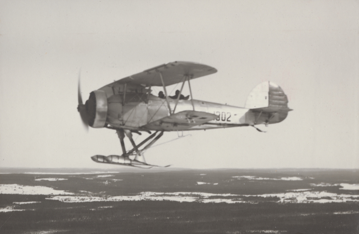 Flygplan S 7 Hawker Hart märkt nr 1302 i luften över Jämtland, vintertid. Flygbild från sidan.

Text vid foto: "Lätt bombplan B 4 - Hawker Hart. HK. F 1, F 4, F 6, mm. 1936-. (Till en början kallat 'S 7'). B 4 över Jämtland."