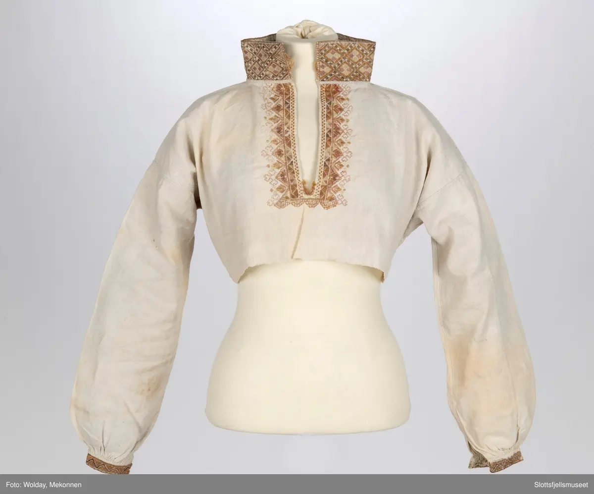 Skjorte til kvinnedrakt. Stående krage. Broderier på mansjetter og krage.