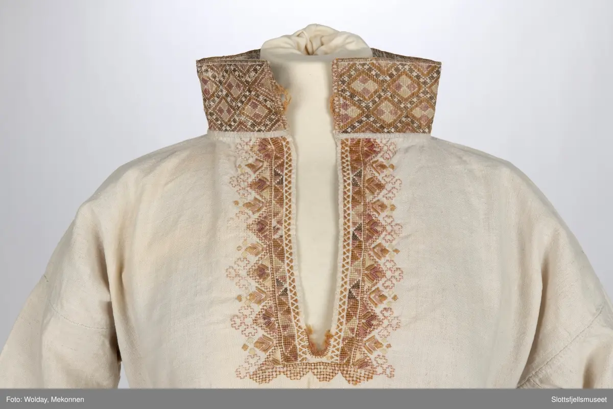 Skjorte til kvinnedrakt. Stående krage. Broderier på mansjetter og krage.