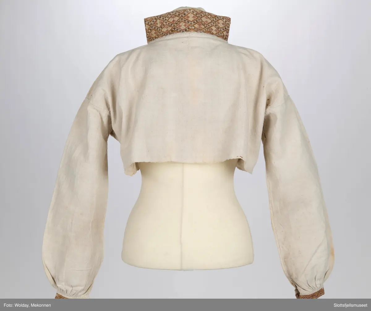 Skjorte til kvinnedrakt. Stående krage. Broderier på mansjetter og krage.