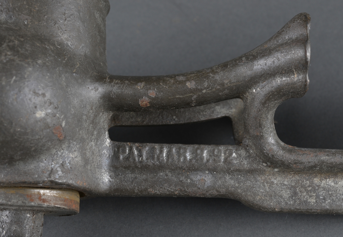 Redskap til kverning av mandler.
Laget i metall, for å feste til bord eller annet. Sveiv med trehåndtak