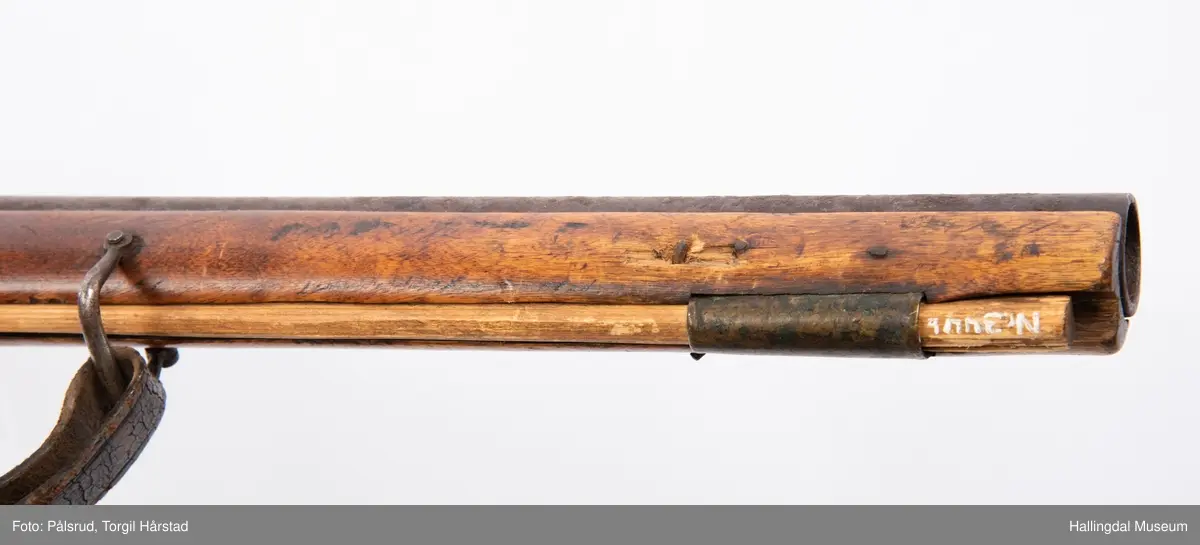 Gevær, modell fra 1769 - 1793, som er ombygd fra flintlås til perkusjonslås. Vært brukt av "Norske Gevorbne Jeger Corps" og senere av soldat nr. 90 i "Telemarkske Nationale jeger Corps Westenfjeldske Compani" i perioden 1818 - 1839. Geværet mangler kolbekappe, men har antatt original reim i brunt lær med messingknapp. Ladestokk i tre.
