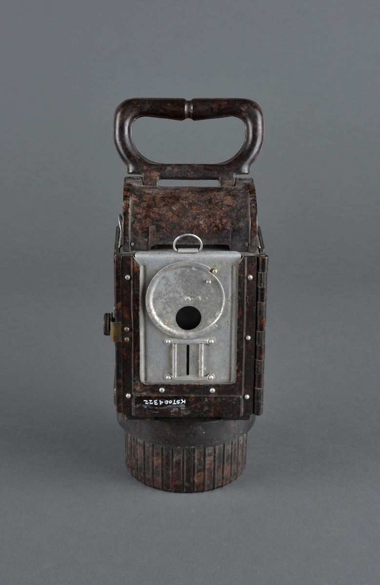 Dette er en bunkerslykt fra 2. verdenskrig. Lykta ble brukt i bunkersannleg av tyske styrker. 
Kan blendes ved å skyve et metallfilter foran lysåpningen. 
Håndtak og festeanordning bak for å henge opp lykta på vegg eller annet.