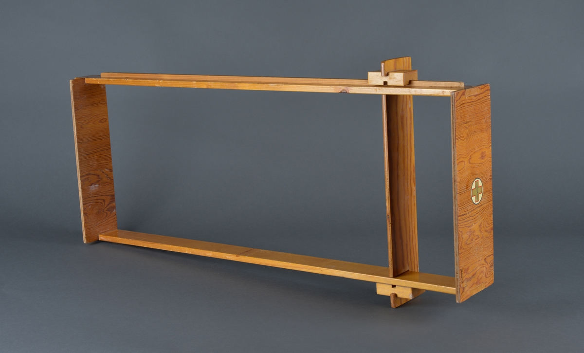 Innretning for å måle spedbarn/små barn
Består av ei avlang treramme hvor det er festet en skyvbar hylle. Langs ene langsiden er det festet et metermål. 
Antatt brukt for å måle nyfødte og /eller barn på småbarnskontroll.