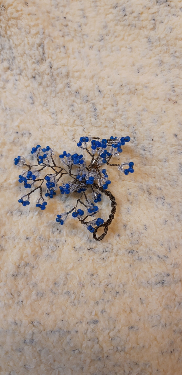 Glassperler tredd på messingtråd