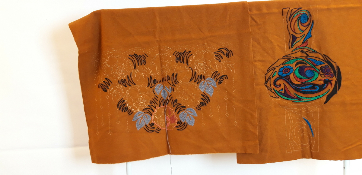 2 stoffstykker, rustrødt med uferdig broderi, antagelig møbeltrekk